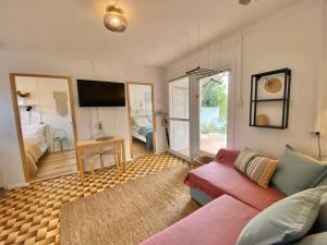 a living room with a pink couch and a bedroom at Bánhiday M4 Weekendhouse in Balatonakarattya
