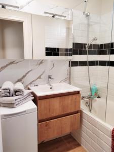 a bathroom with a sink and a shower and a tub at Le cosy duplex centre in Dinan