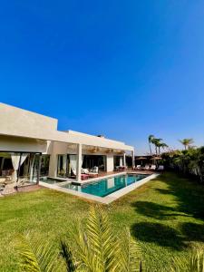 a large house with a swimming pool in the yard at Villa Alanaé piscine chauffée in Douar Bellouk