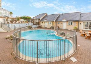 ein großer Pool mit einem Zaun um ihn herum in der Unterkunft Porth Veor in Newquay