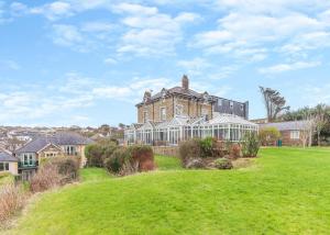 ein großes Haus mit einem Rasen davor in der Unterkunft Porth Veor in Newquay + 24 Fotos