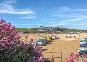 Ein Haufen Autos, die am Strand geparkt sind. in der Unterkunft Porth Veor in Newquay
