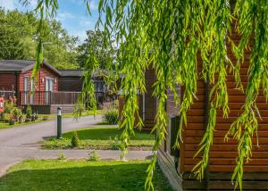 a house with a tree in front of it at Roydon Marina Village in Roydon