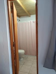 a bathroom with a toilet and a door open at departamento mar de ostende in Ostende