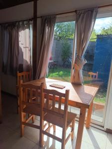 a wooden table with a chair and a window at departamento mar de ostende in Ostende