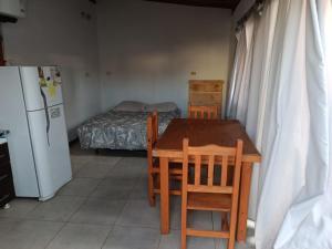 a kitchen with a table and chairs and a bed at departamento mar de ostende in Ostende