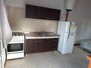 a kitchen with a stove and a white refrigerator at departamento mar de ostende in Ostende