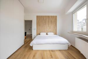 a bedroom with a white bed and a window at 1 bedroom flat 55m2 in the city in Luxembourg +8 photos