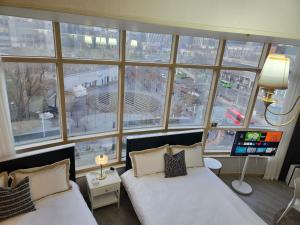 two beds in a room with a large window at Gleam House in Seoul