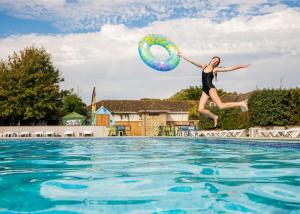 una mujer saltando en el aire junto a una piscina en Shorefield Country Park, en Milford on Sea