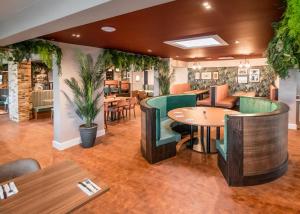 Un restaurante con mesas y sillas de madera y plantas. en Shorefield Country Park, en Milford on Sea 126 fotos más