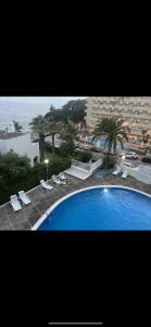 ein großer blauer Pool neben einem Strand in der Unterkunft Clear Water Beach Apartments in Salou