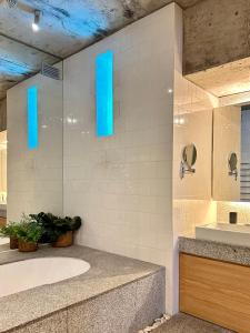 a bathroom with a tub and a sink with blue lights at Silver Bay Villa in Stompneusbaai +9 photos