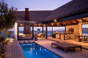 a house with a swimming pool and a patio at Silver Bay Villa in Stompneusbaai