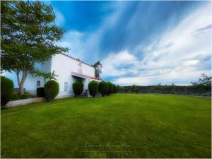 un edificio bianco con un ampio prato di Cortijo señora de las Angustias 2 ad Alanís