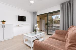 ein Wohnzimmer mit Couch und Tisch in der Unterkunft Home2Book Tranquil Escape Corralejo Community Pool in Corralejo