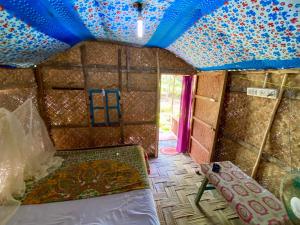 ein Zimmer mit einem Bett und einem Zelt. in der Unterkunft Garden View Restaurant and Home Stay in Neill Island