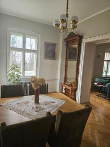 a dining room table with a vase of flowers on it at Willa "Pod Bukiem" in Złoty Stok
