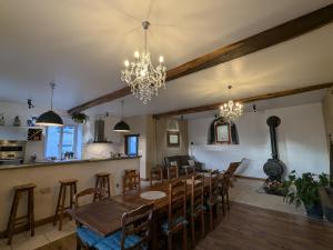 a dining room and kitchen with a table and chairs at Gîte historique et moderne, capacité flexible - FR-1-585-170 in Mouzay