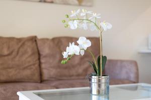 eine Vase weißer Blumen auf einem Couchtisch in der Unterkunft Home2Book Tranquil Escape Corralejo Community Pool in Corralejo