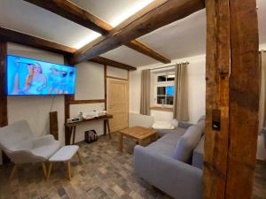 a living room with a couch and a flat screen tv at Historisches Bauernhaus für 8 Personen mit Luxus und Natur auf 2 Etagen ideal für Familien und Hunde 2500m2 eingezäunt an der Ostsee in Niepars