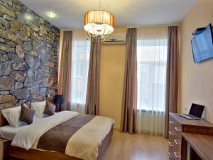 a bedroom with a large stone wall at Golden Gate Inn in Kyiv