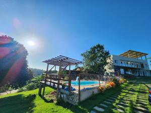 a pool in a yard next to a building at Pousada Canto do Sabiá in Piúma