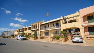 two cars parked in front of a building on a street at Mediterranea 10 tus momentos junto al mar Villaricos in Cuevas del Almanzora