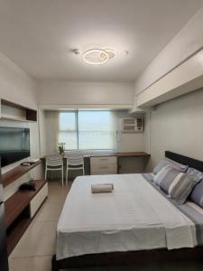 Un dormitorio con una cama grande y un comedor. en Lourdes Bedsit Horizon 101, en Cebú