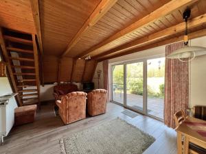 a living room with two chairs and a sliding glass door at Rehblick RE11 in Sögel