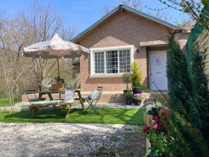 a house with a picnic table and an umbrella at The Lake house Feneos in Archaia Feneos