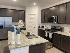 a kitchen with wooden cabinets and a counter top at 4-BR Cheerful Home Long Term Stay Equipped in Katy in Katy