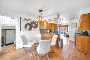 comedor y cocina con mesa de cristal y sillas blancas en Vintage 8BR Farmhouse With Hot Tub Spacious Yard, en Port Colborne