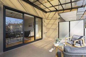 a screened in porch with a couch and a table at Domi Rentals The Chadstone Homes in Chadstone