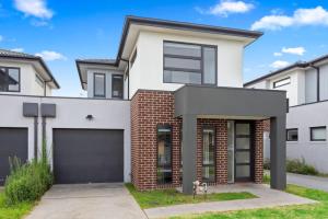 a house with a garage in front of it at Domi Rentals - The Mill Residence in Clayton North