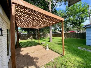 una pérgola de madera al costado de un patio en 3-BR Getaway Ideal for Families, en Houston