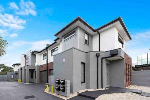 a large white building with a parking lot at Domi Rentals - The Hampton Homes in Moorabbin