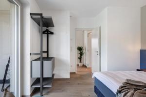 een slaapkamer met witte muren en een bed en een trap bij New Opening Vinea Guesthouse in Cornedo all'Isarco