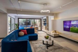 a living room with a blue couch and a tv at Exclusive stay with luxury touches at 22 by spacey #55 Studio in Maadi in Cairo