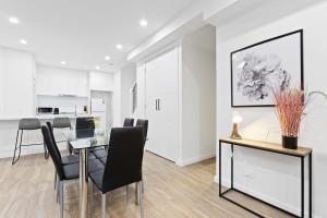 a dining room with a table and chairs at Domi Rentals - The Hampton Homes in Moorabbin