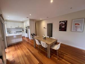 a kitchen and dining room with a wooden table and chairs at The Blackburn Residences in Notting Hill
