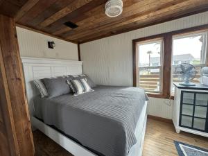 una camera con letto, finestra e ventilatore di Gibbs Cottage 5 Little White Egret a Port Aransas
