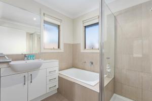 un bagno bianco con lavandino e doccia di Domi Rentals The Blackburn Residence a Notting Hill