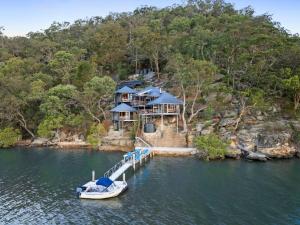 a boat is docked at a dock with a house at Pagoda Point in Bar Point