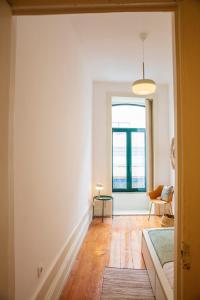 ein Wohnzimmer mit weißen Wänden und einem Fenster in der Unterkunft Casa Romero - Family & Friends, Surf & Beach in Matosinhos