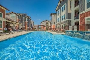 a swimming pool at a apartment complex with buildings at Spring Modern 2 king bed Long-term Condo in Spring