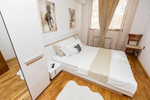 a small bedroom with a bed and a mirror at Апартамент “Djanina 2” in Sandanski +16 photos