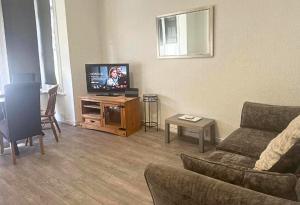 a living room with a couch and a tv at Comfy Staycation! 2BR City Centre Westcliff Beach & High St by Everhome Ltd in Southend-on-Sea