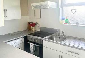 a kitchen with a sink and a dishwasher at Comfy Staycation! 2BR City Centre Westcliff Beach & High St by Everhome Ltd in Southend-on-Sea