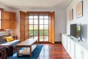 a living room with a couch and a tv and a table at Piso en Pedreña - 32001 in Pedreña